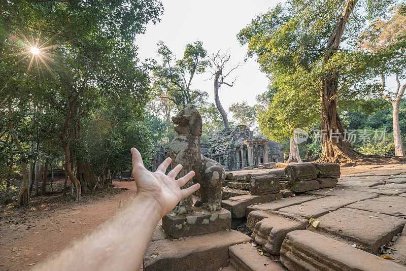 夕阳西下，人的手伸向太阳。阳光效应，吴哥窟古寺，古遗址。能源人环境旅游理念。Ta Prohm，暹粒，亚洲。